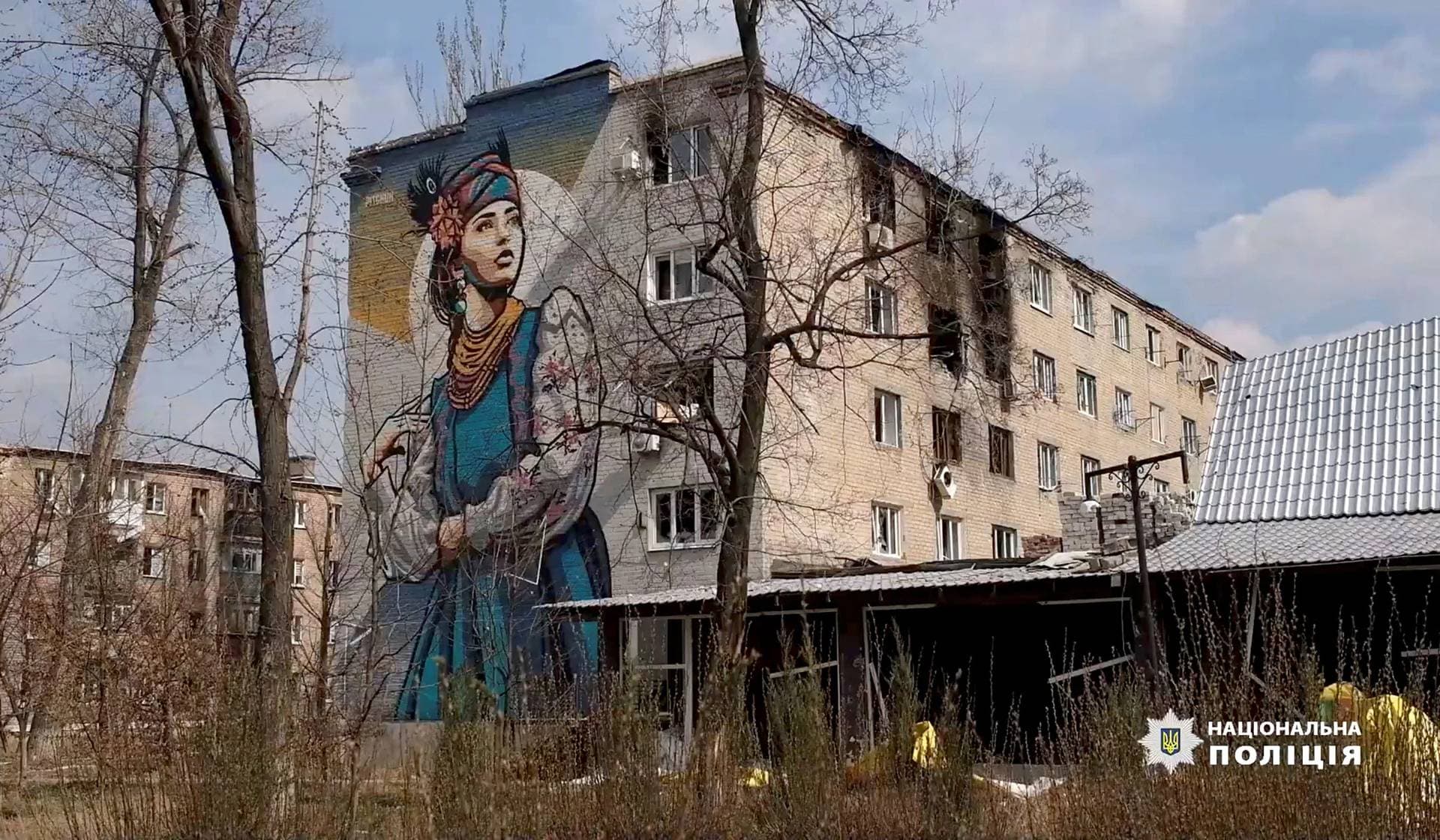 A damaged building with a mural in Avdiivka