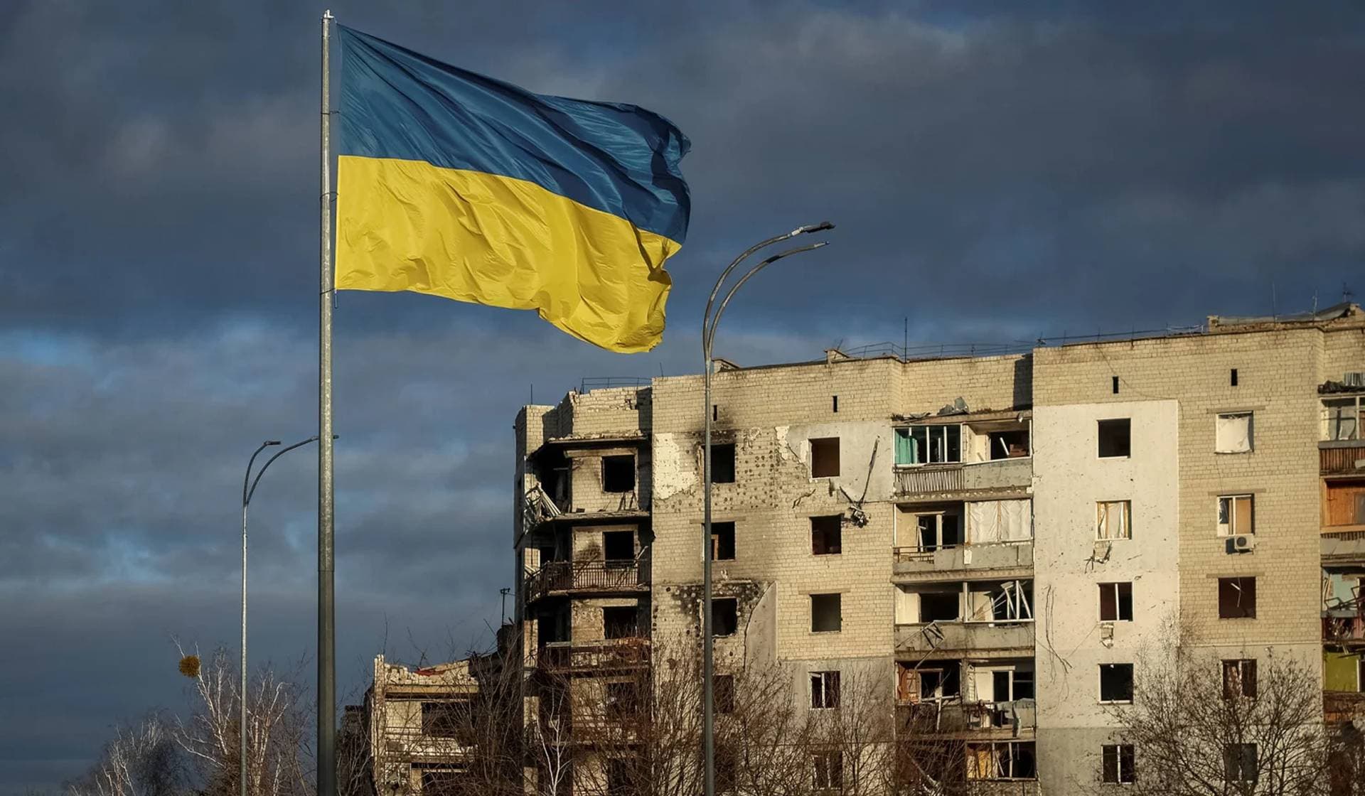 A Ukrainian national flag flies near buildings destroyed by a Russian military strike in Borodianka