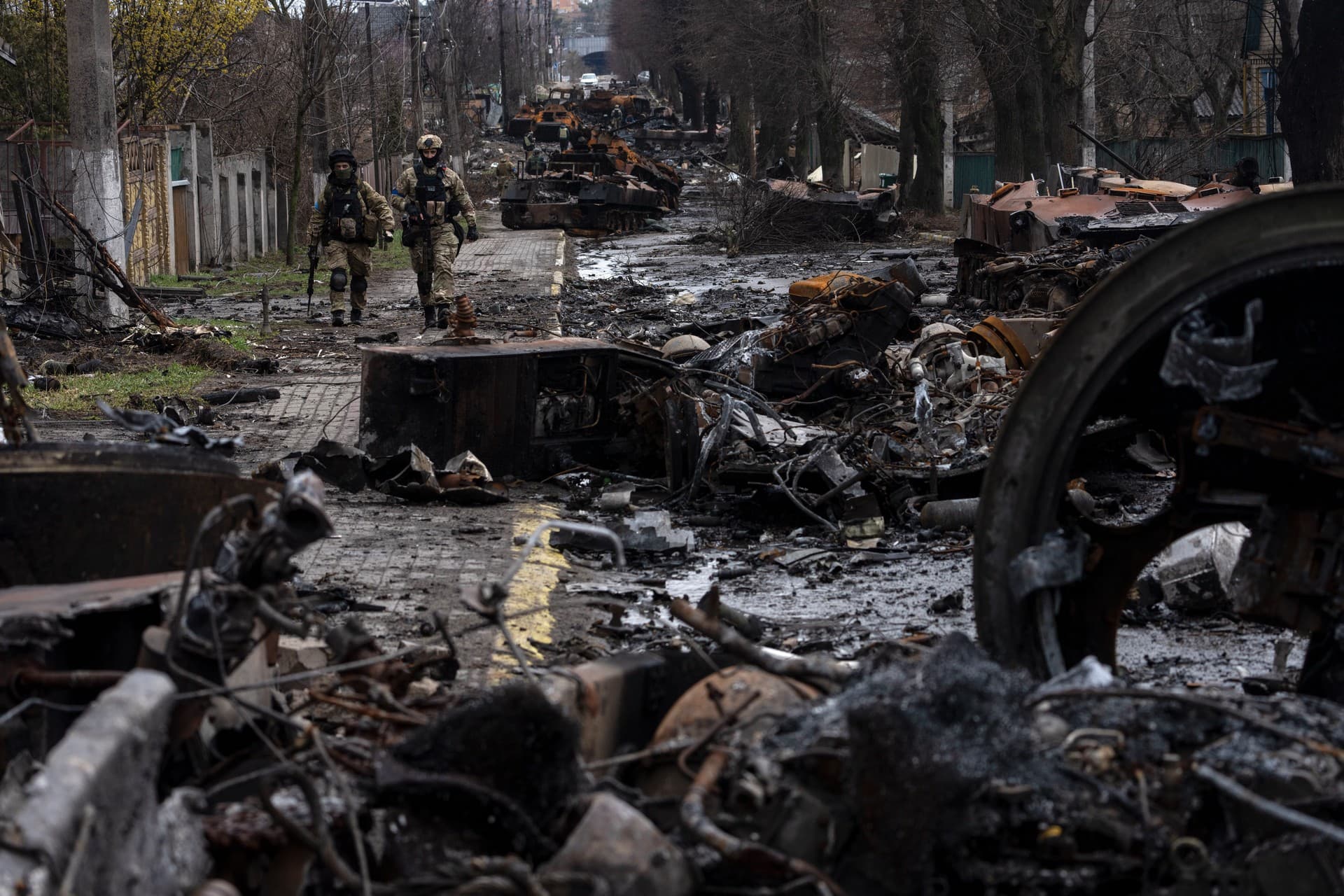 Soldiers walk amid destroyed Russian tanks in Bucha, on the outskirts of Kyiv.