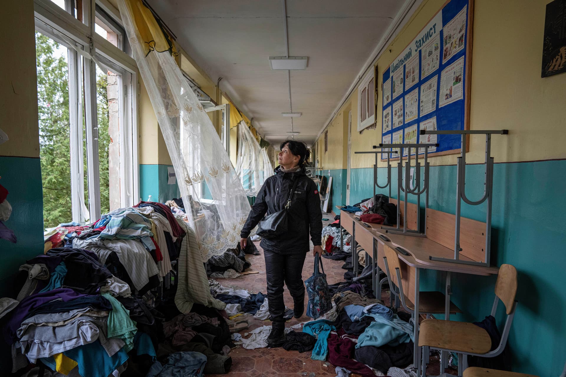 School official Iryna Homenko walks in the hall of a school damaged by an airstrike from Russian forces in Chernihiv