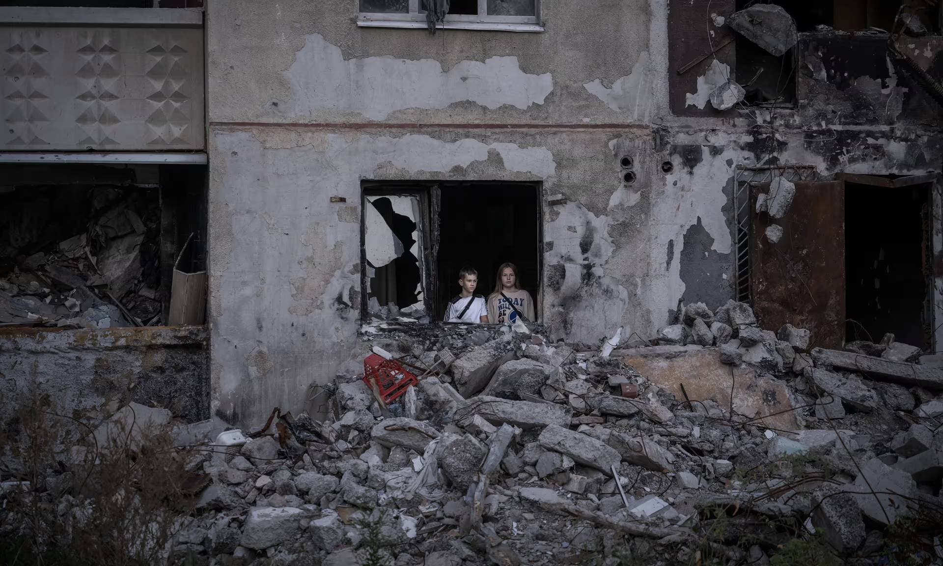 Two young children inside a damage building following a Russian attack in the Staryi Saltiv