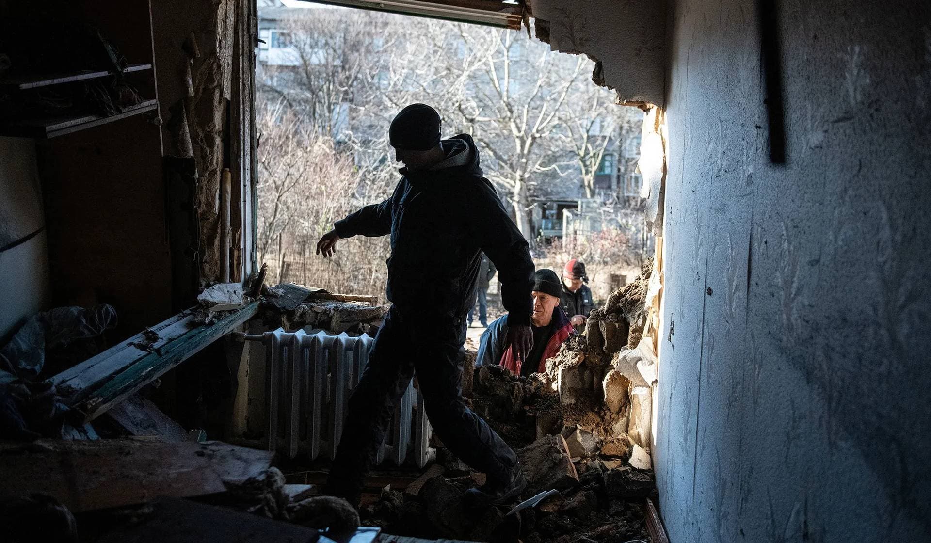 A resident walks inside an apartment damaged by recent shelling in Donetsk