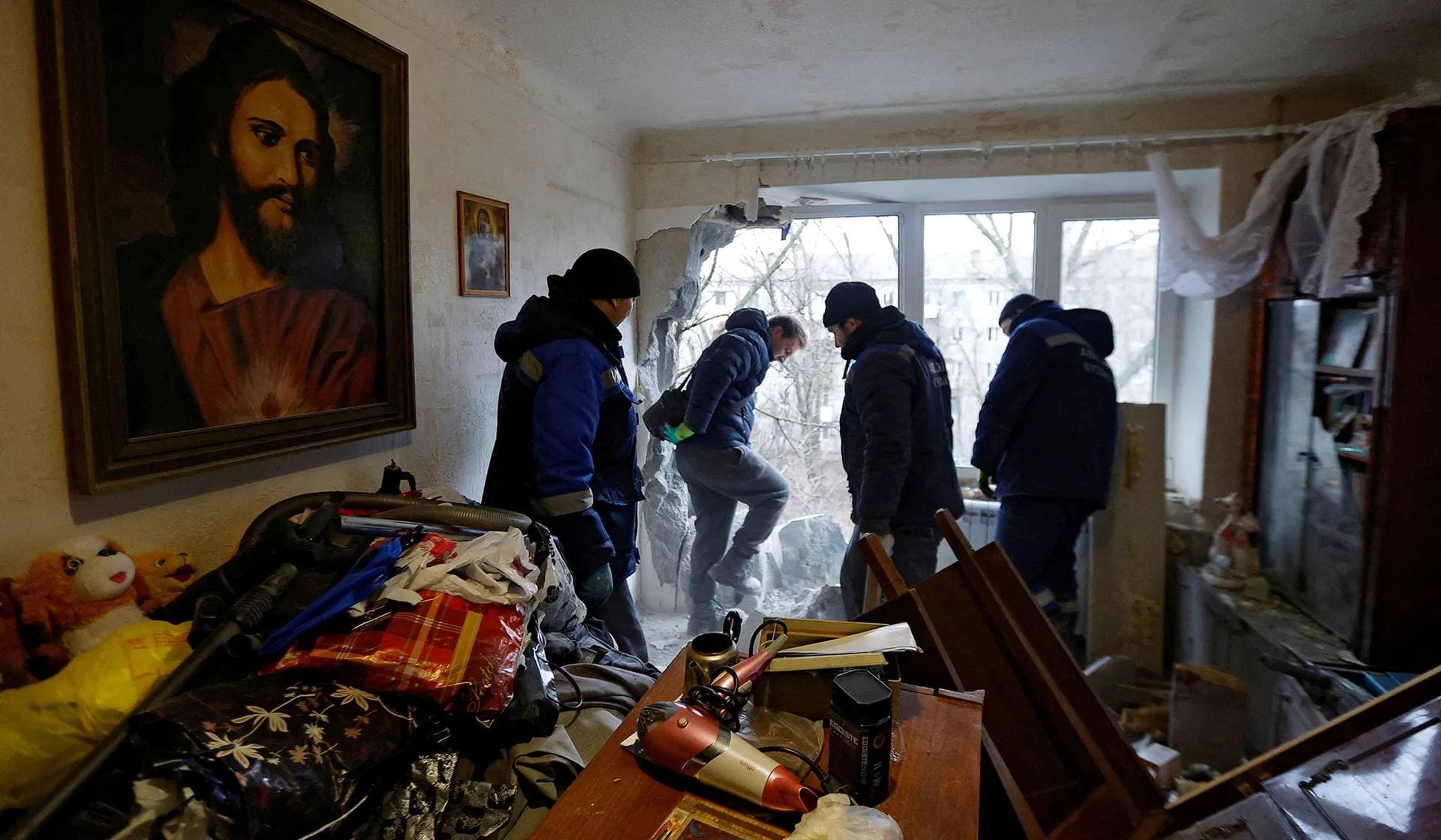 Workers remove debris from an apartment which was damaged by recent shelling in Horlivka