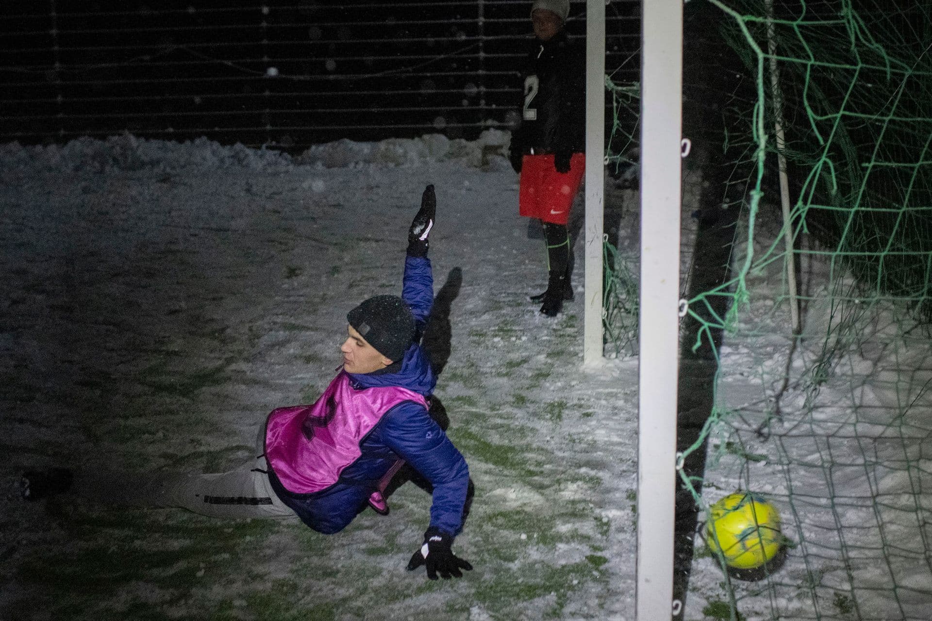 A goal is scored as people play in a soccer game during a blackout in Irpin