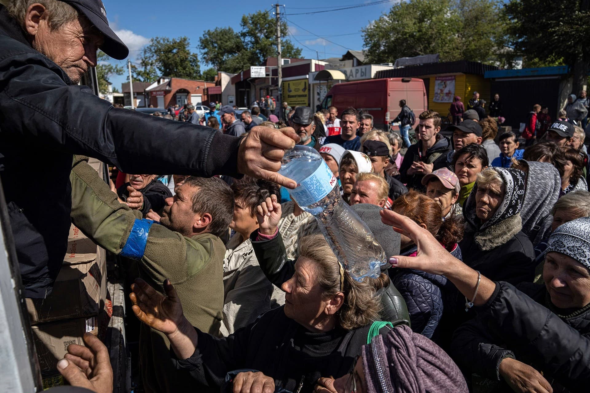 People receive water as humanitarian aid in the recently retaken area of Izium