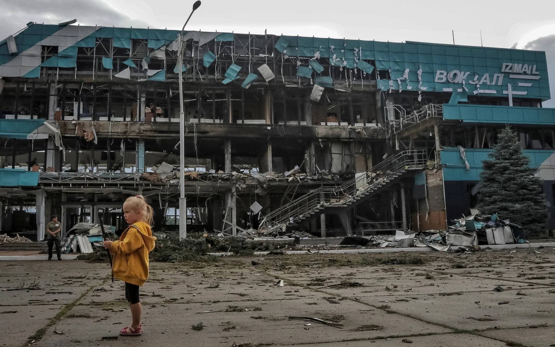 A girl stands outside the Marine Terminal building damaged in the Russian drone attack on the port infrastructure of Izmail