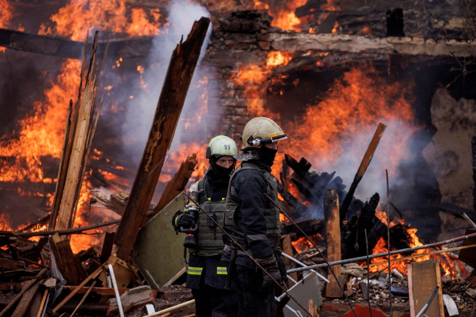 Firefighters work at a burning building in Kharkiv