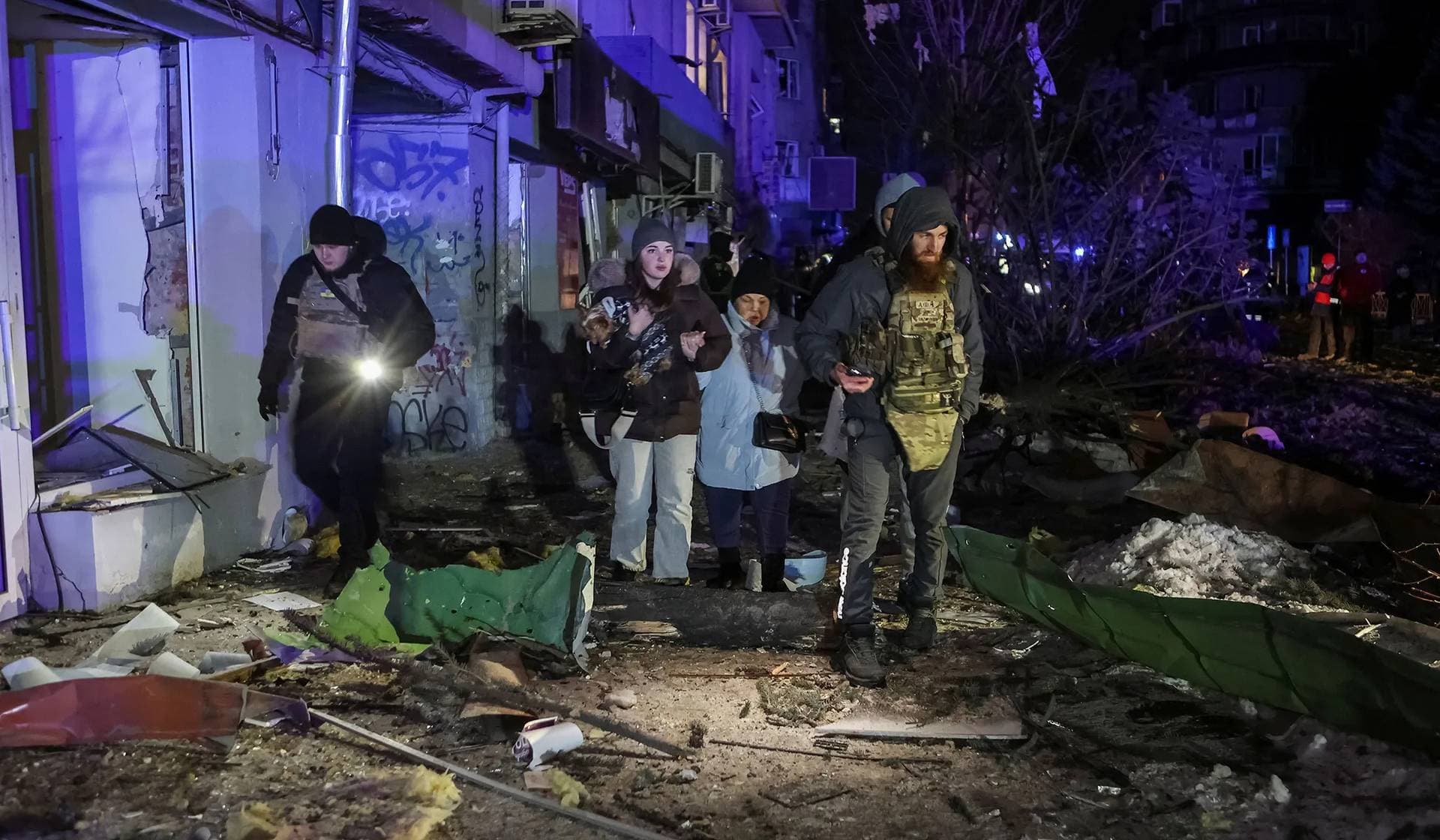 Local residents leave a site of residential buildings heavily damaged during a Russian missile attack in central Kharkiv