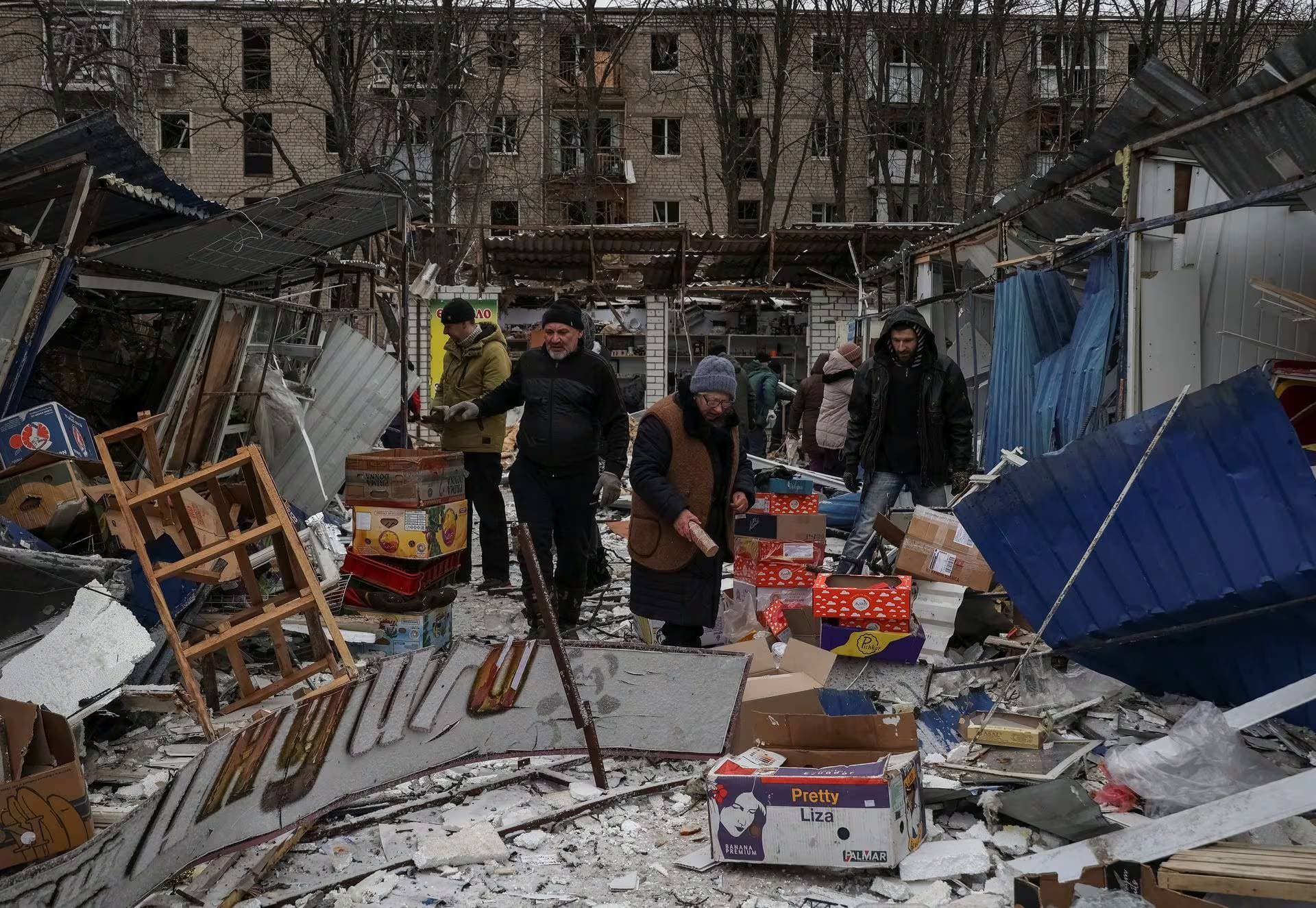 Residents collect goods at a street market destroyed during a Russian missile attack in Kharkiv