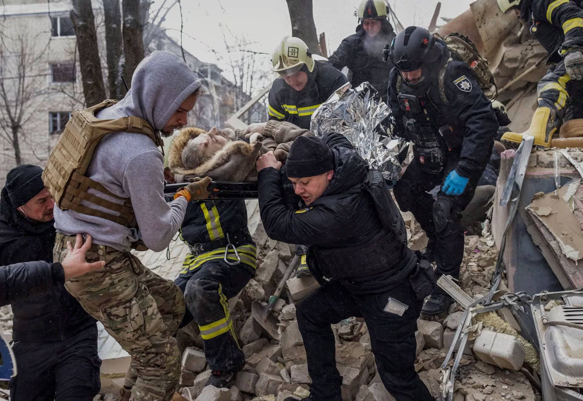 Police evacuate a resident from a residential building heavily damaged during a Russian missile attack in Kharkiv