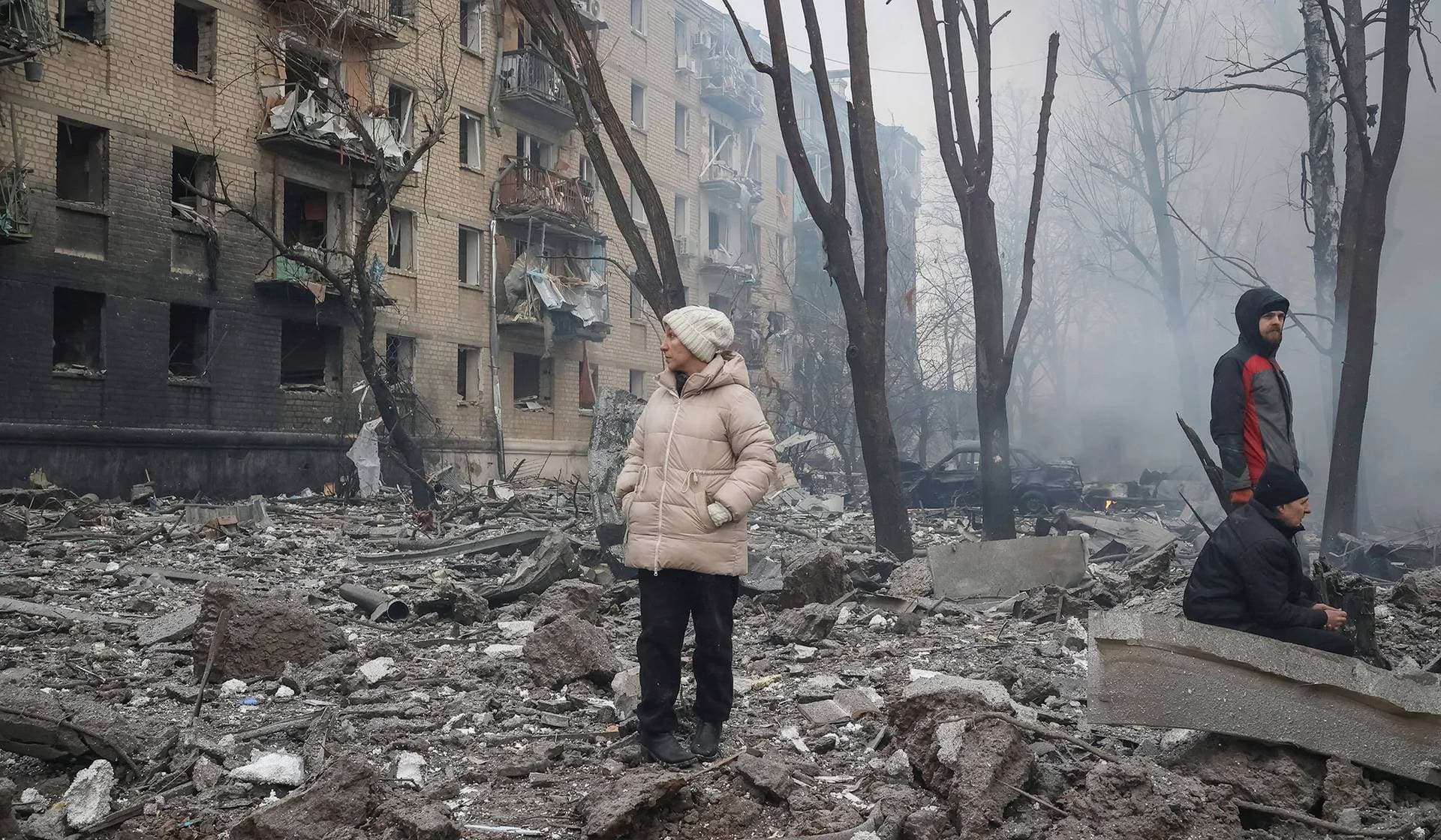 Local residents stand near their apartment building damaged during a Russian missile strike in Kharkiv