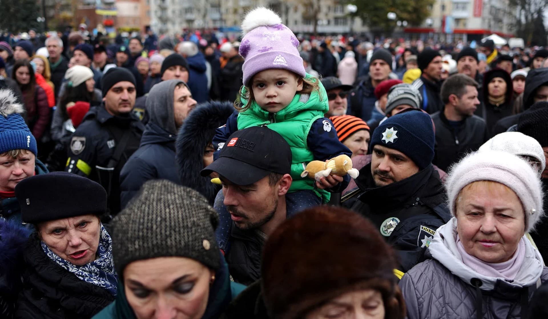 People wait to receive humanitarian aid in central Kherson