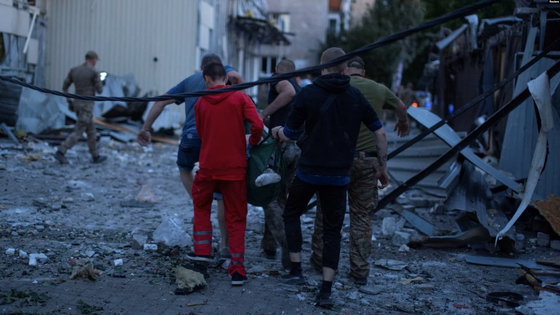 Volunteers carry an injured person away from hotel and restaurant buildings, which were heavily damaged in a deadly Russian missile strike on the city of Kramatorsk