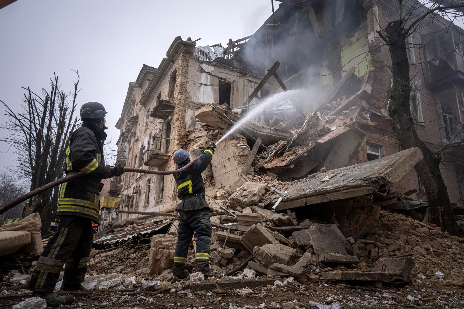 Ukrainian State Emergency Service firefighters work to extinguish a fire at the building which was destroyed by a Russian attack in Kryvyi Rih