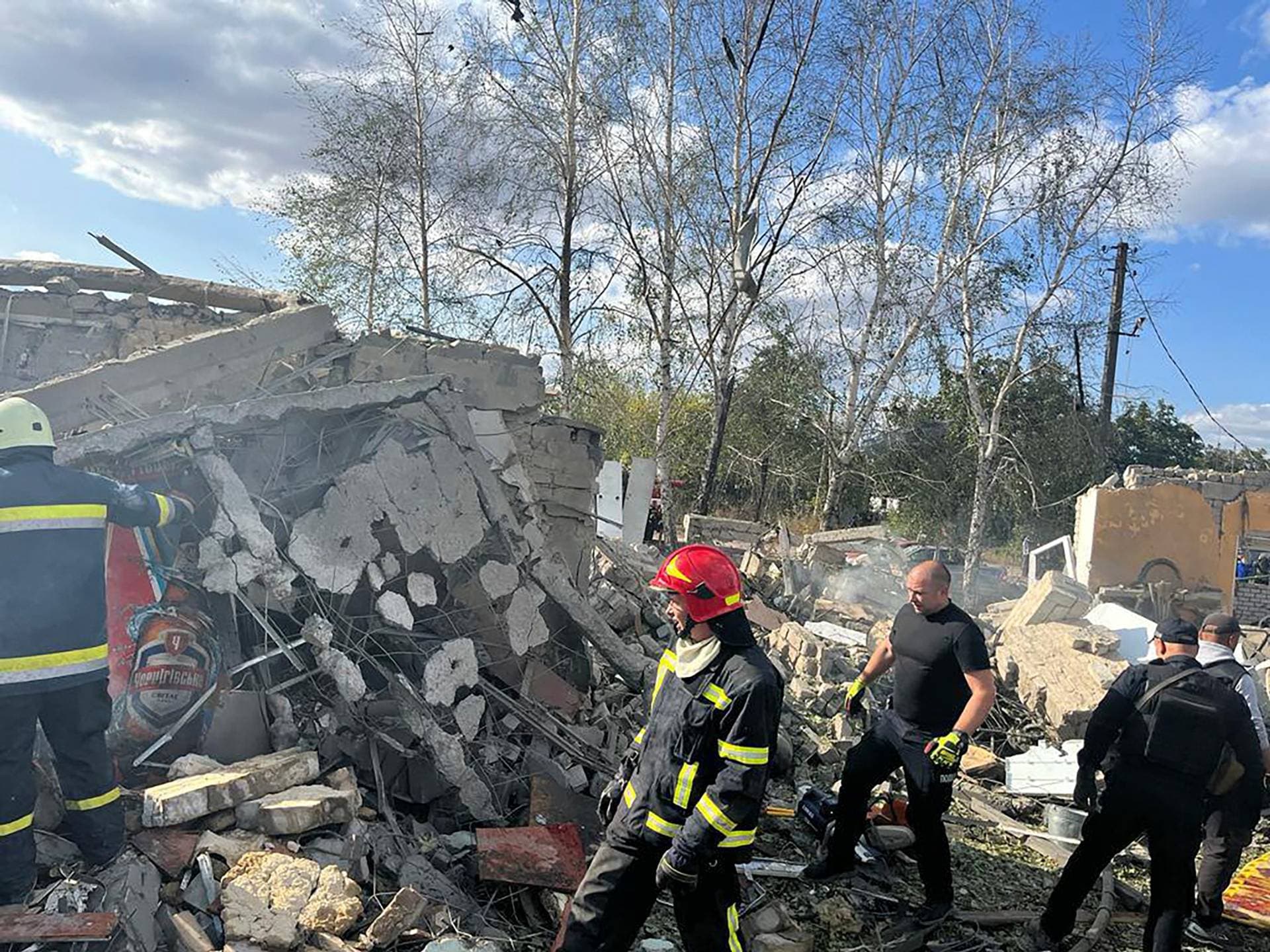 emergency workers search the victims of the deadly Russian rocket attack that killed more than 50 people in the village of Hroza