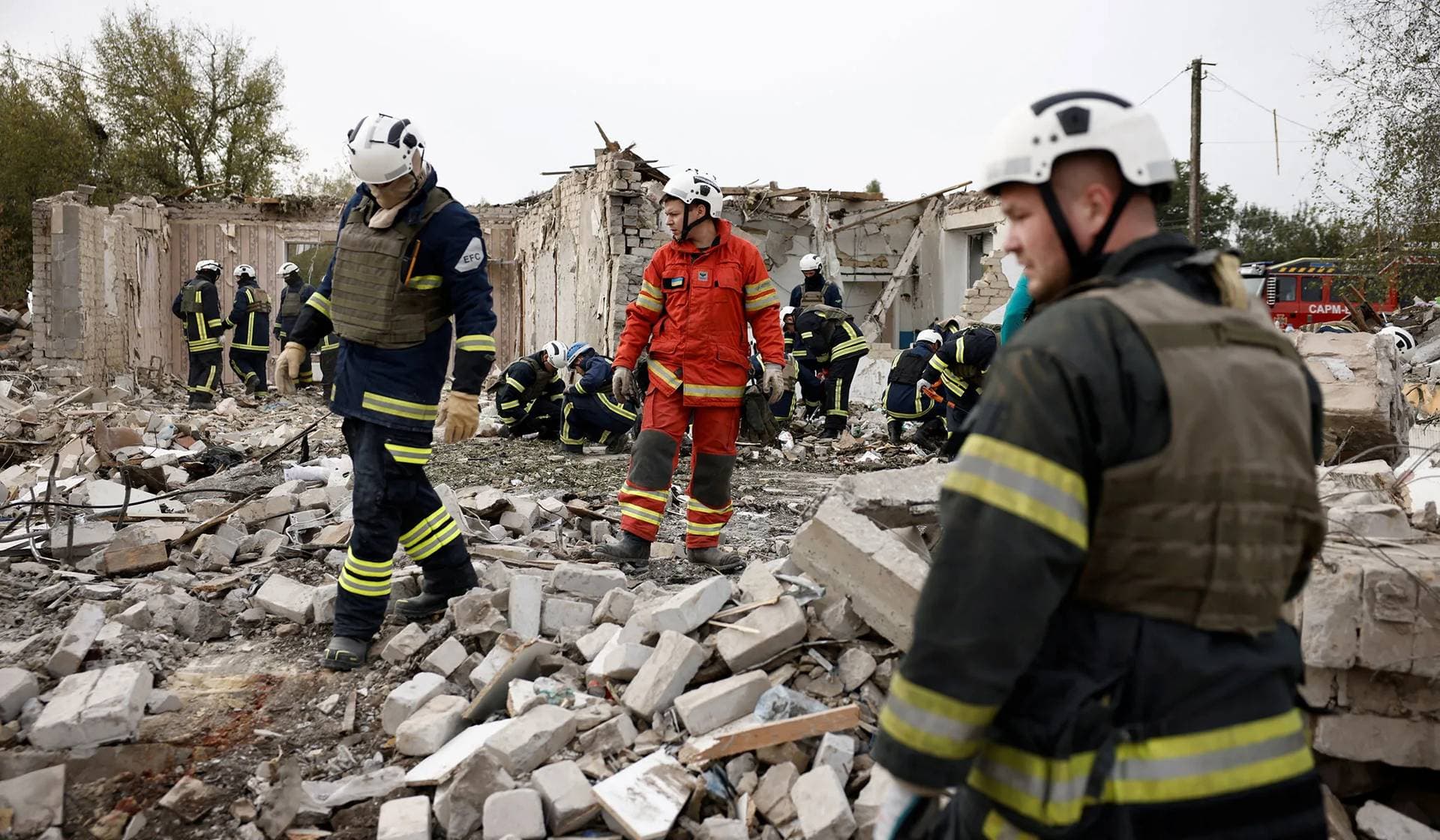 Emergency personnel work at a site of a Russian military strike in the village of Hroza