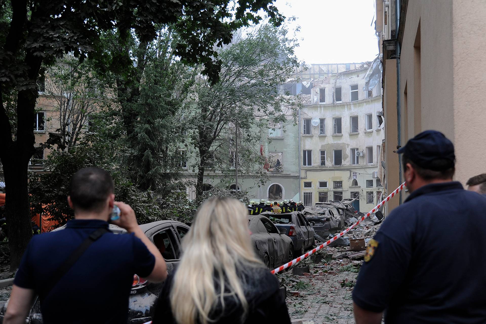 People look at buildings damaged by a Russian missile attack in Lviv