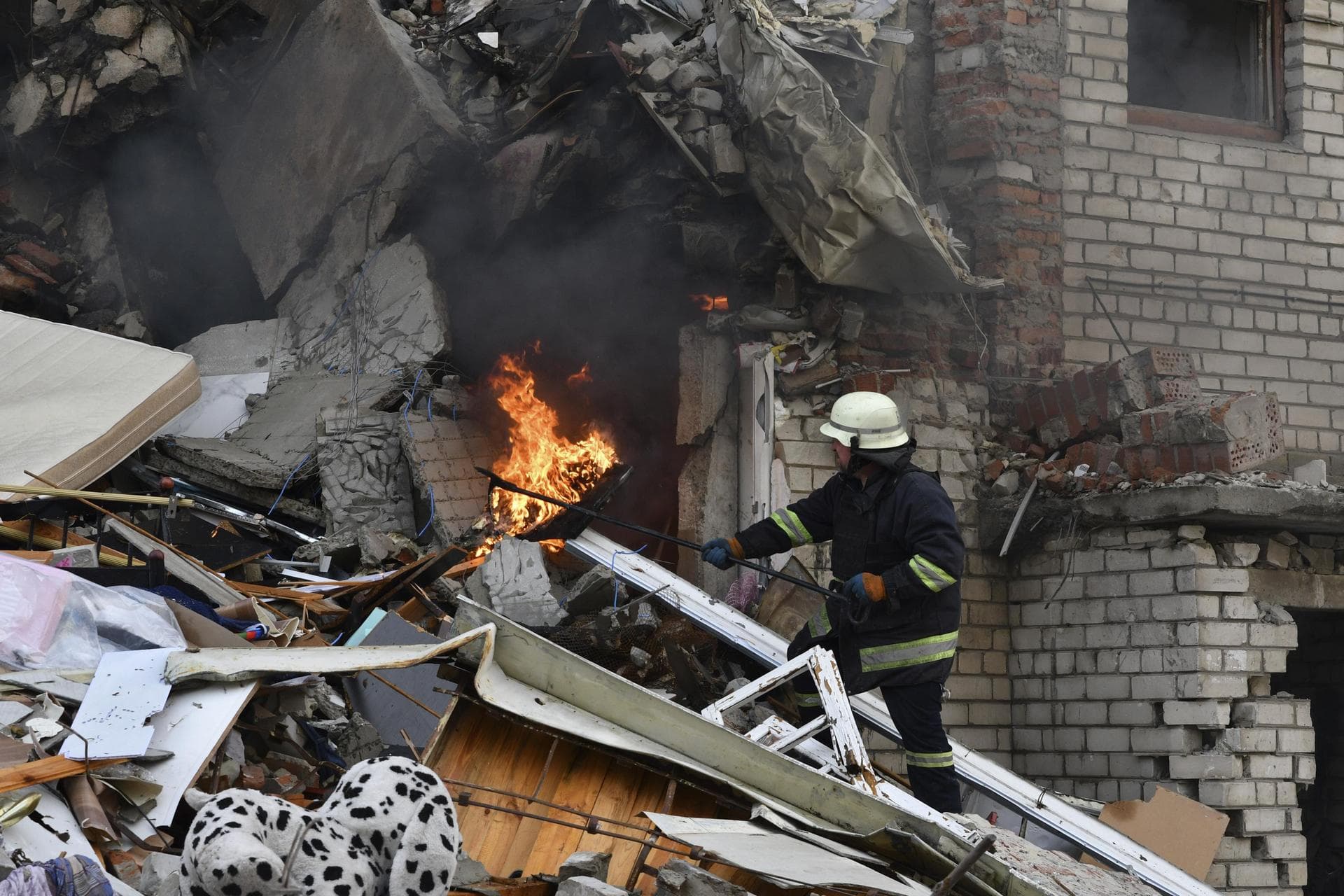 A firefighter works at the scene of a damaged residential building after Russian shelling in the liberated Lyman