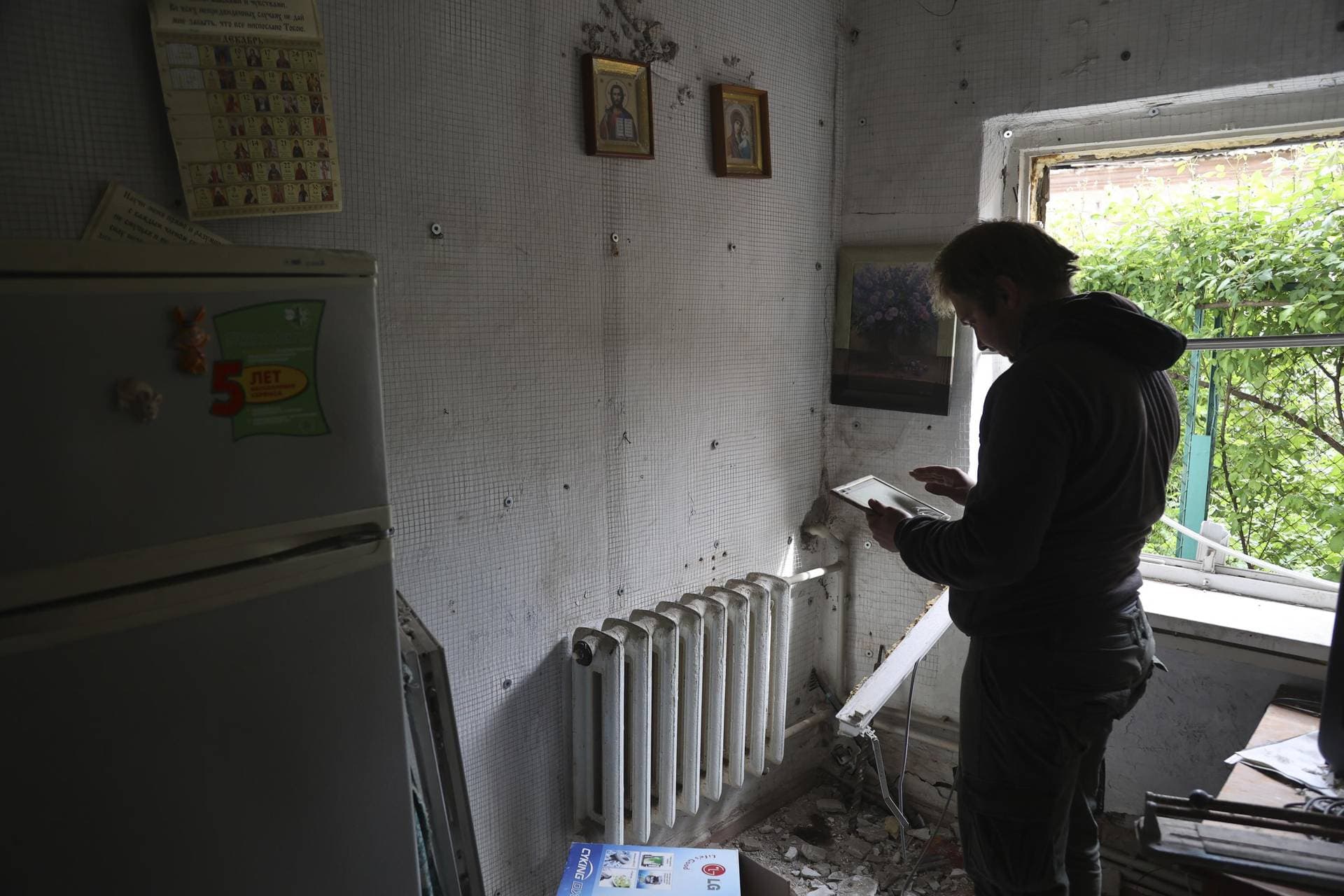 A man stands in a house damaged by shelling in Mariupol