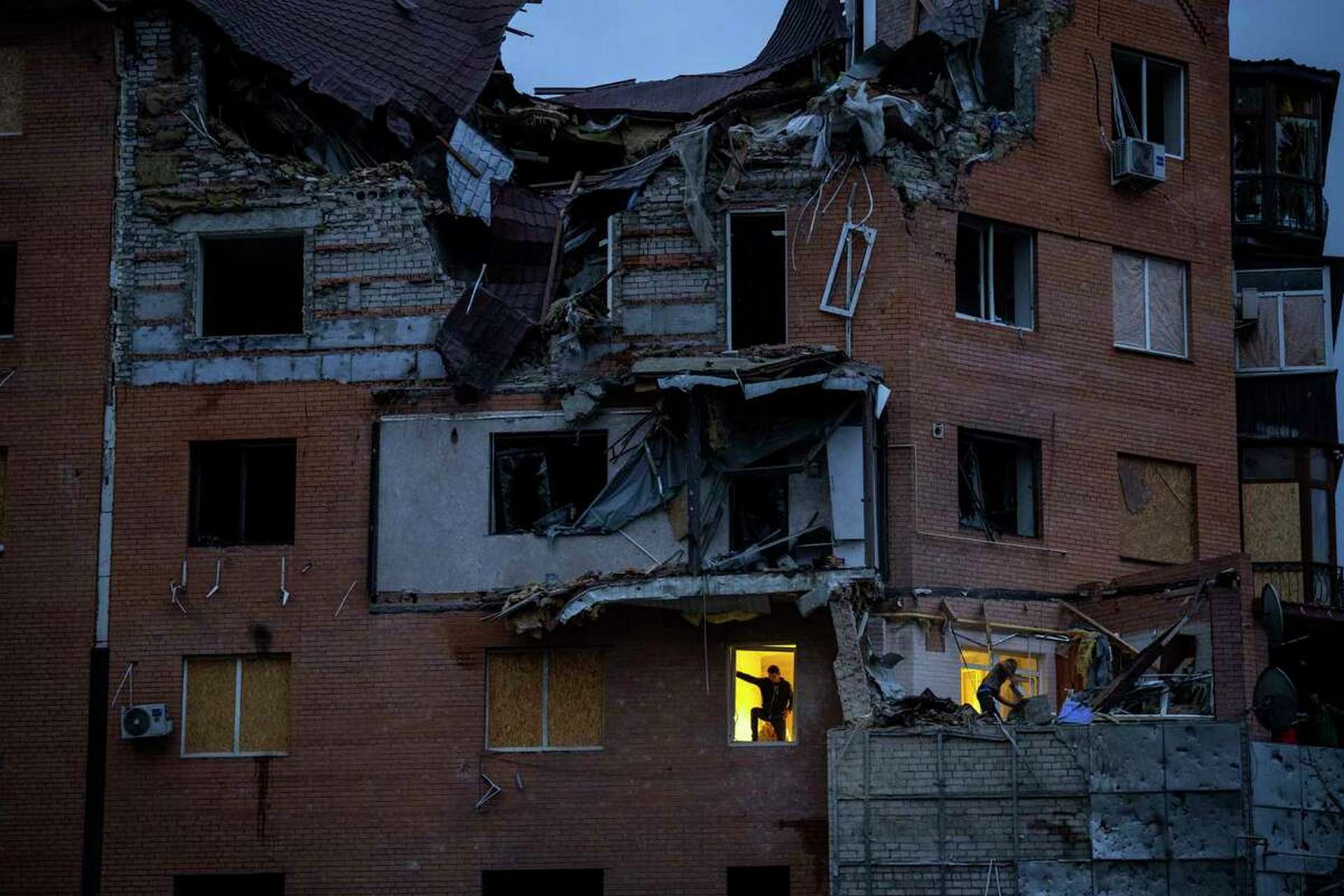 People check the damage at their apartments hit by a Russian missile in Mykolaiv