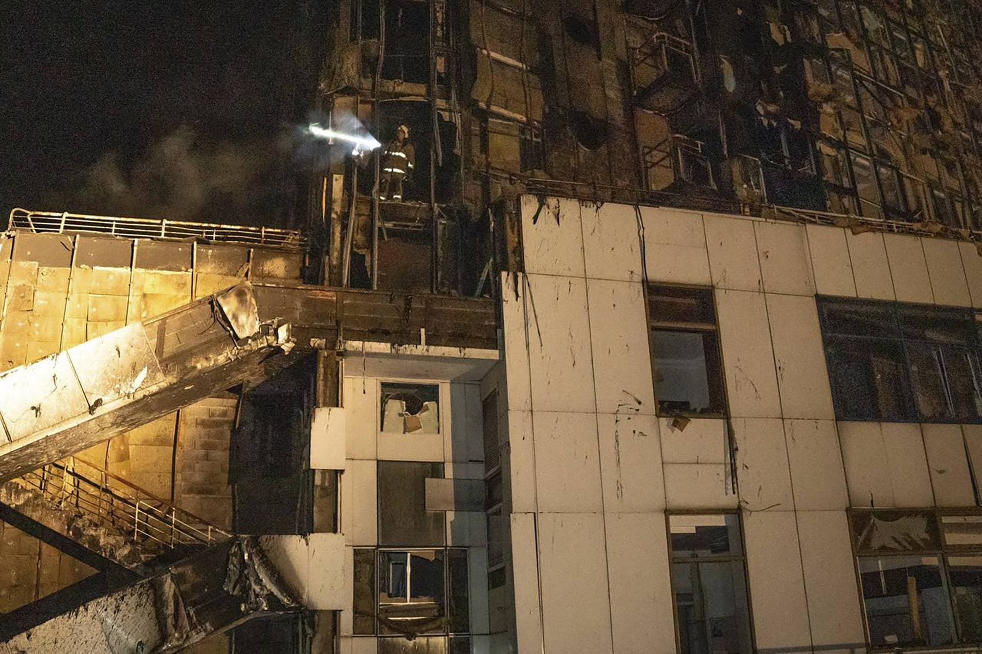 firefighters work to extinguish a fire in a hotel at the seaport after a Russian rocket attack in Odesa