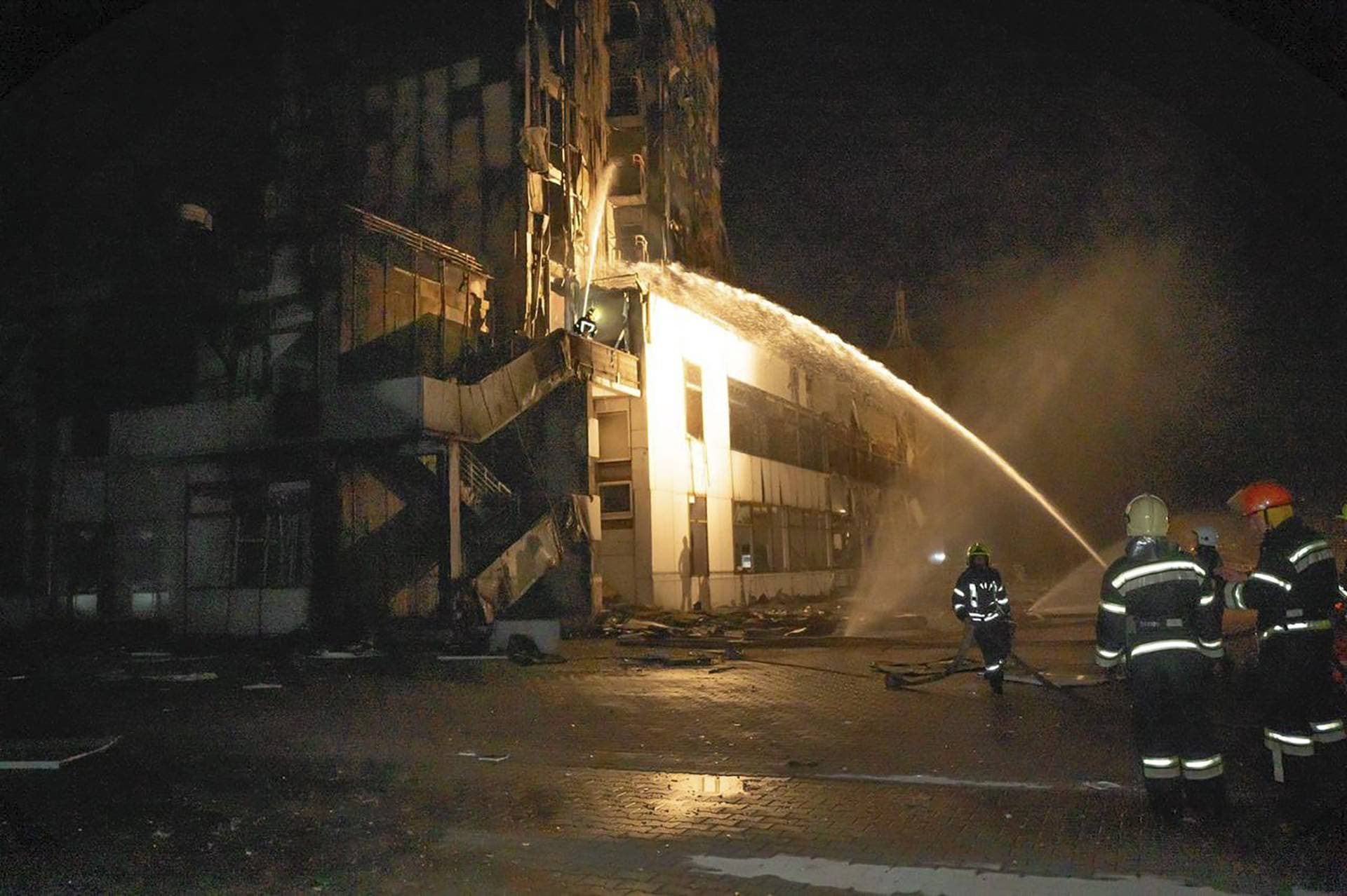 firefighters work to extinguish a fire in a hotel at the seaport after a Russian rocket attack in Odesa