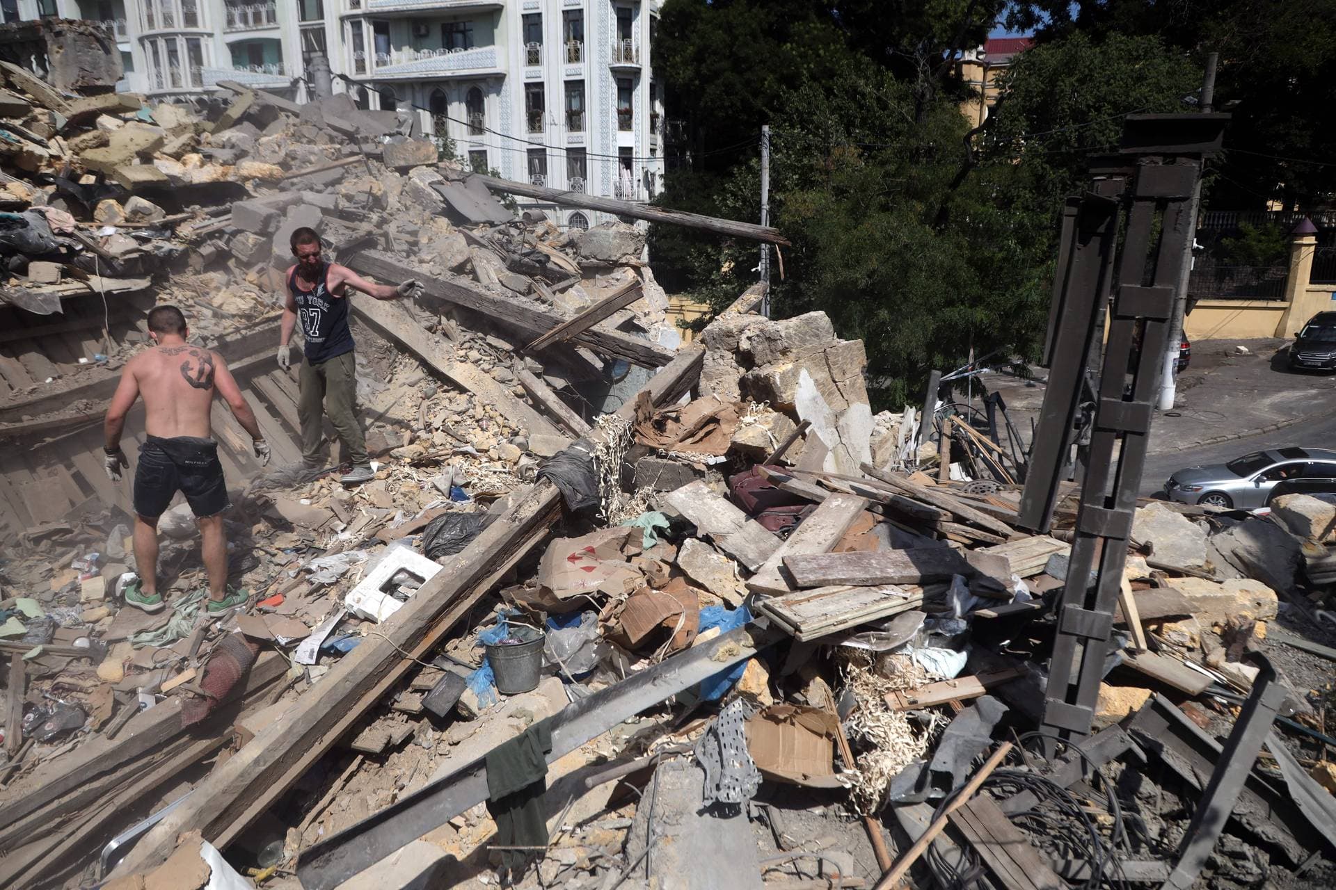 Workers clear the rubble in the center of Odesa on July 24