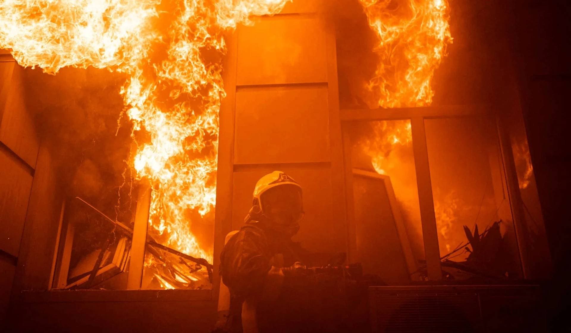 A firefighter works at a site of an administrative building heavily damaged by a Russian missile strike in Odesa