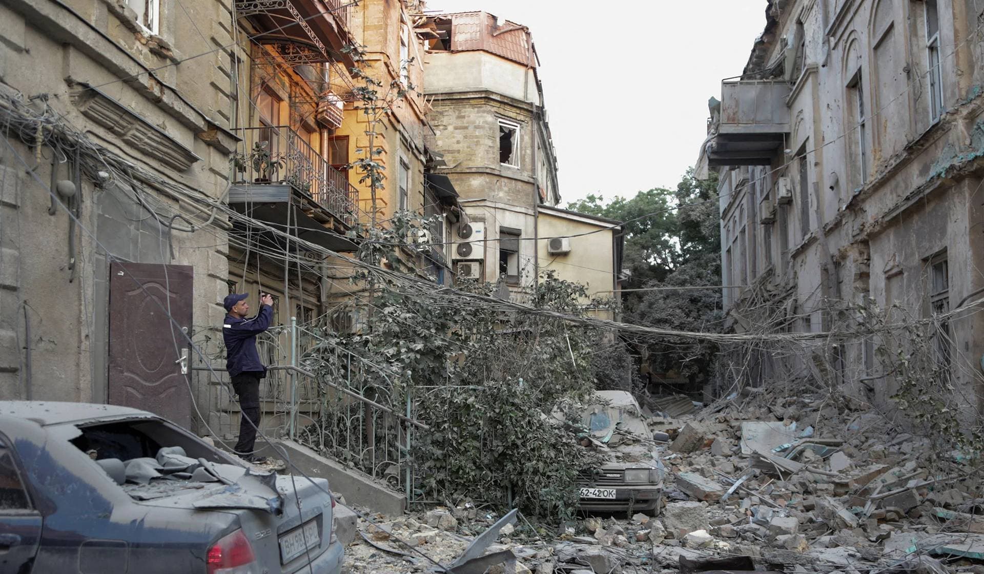 A rescuer takes a picture of a residential building damaged during a Russian missile strike in Odesa