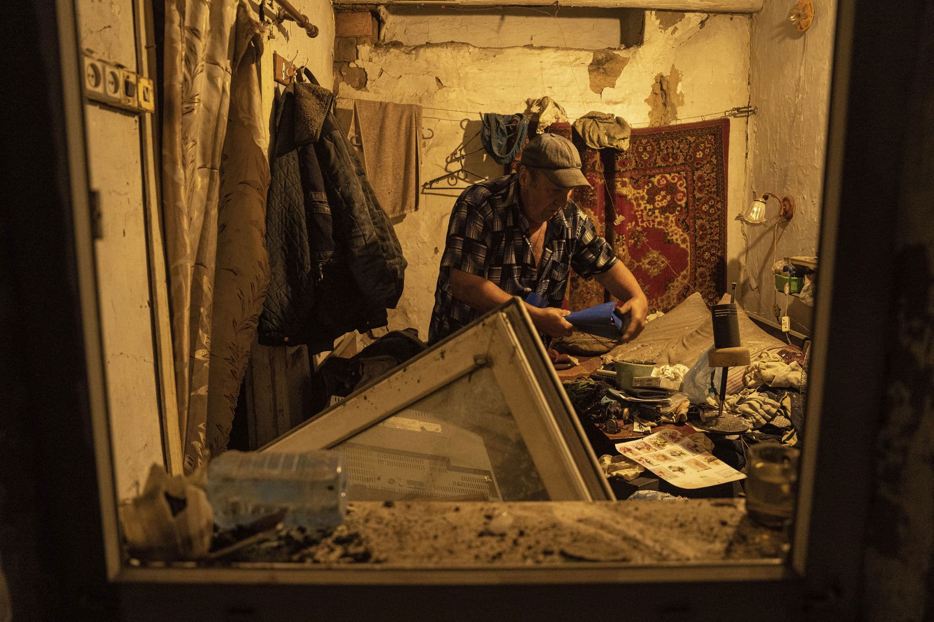 After a rocket hit a residential area in Pokrovsk, Ukraine, a local man collects documents in his house