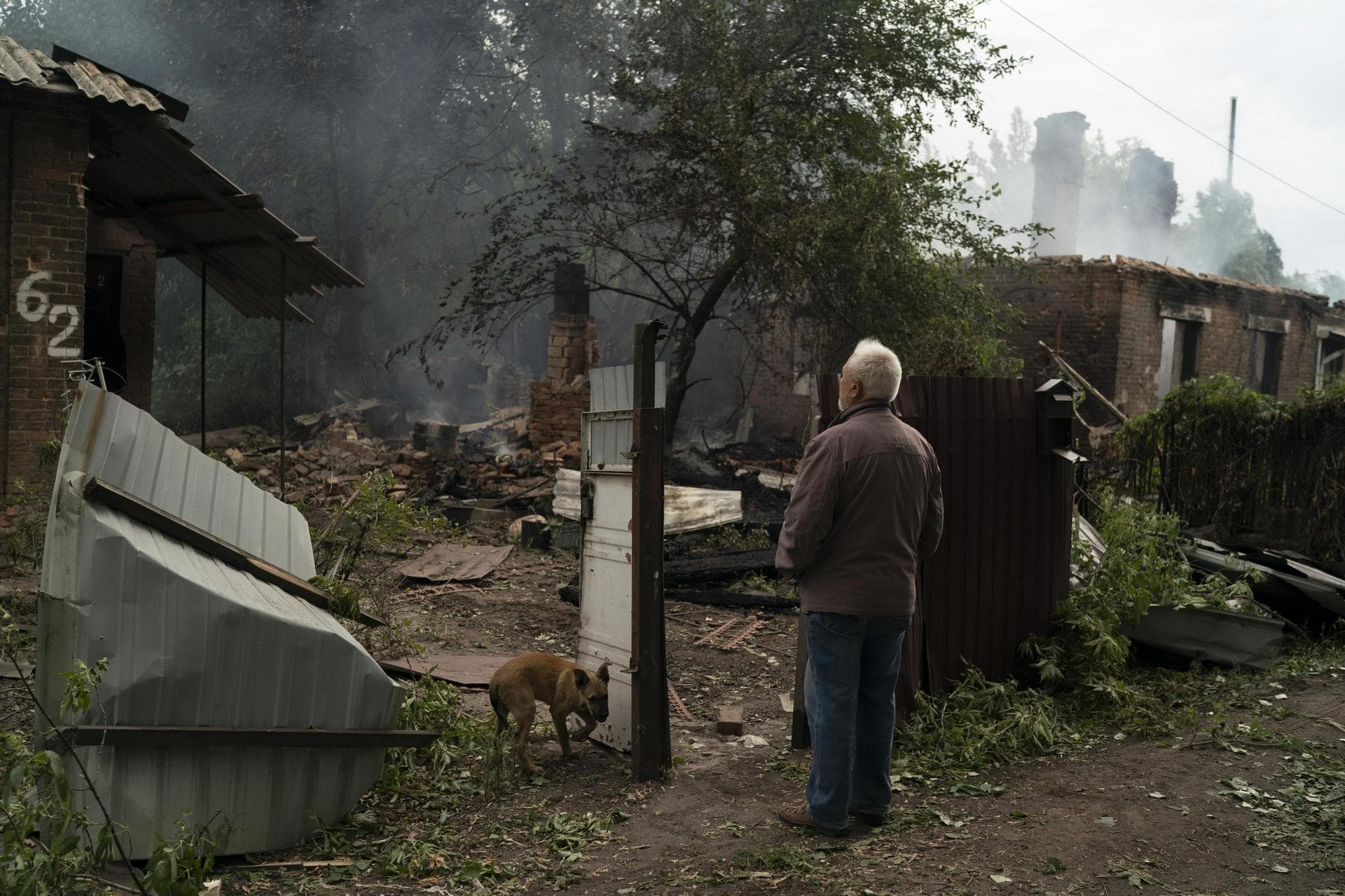 Oleksander Zaitsev stands in front of the house where his friend was found dead after a Russian attack in Pokrovsk region