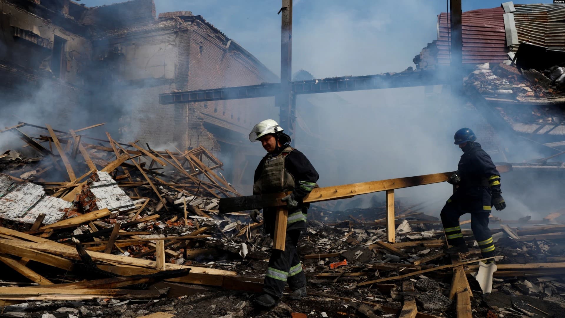 Ukrainian firefighters remove rubble in a factory destroyed by a Russian strike in the city of Slovyansk
