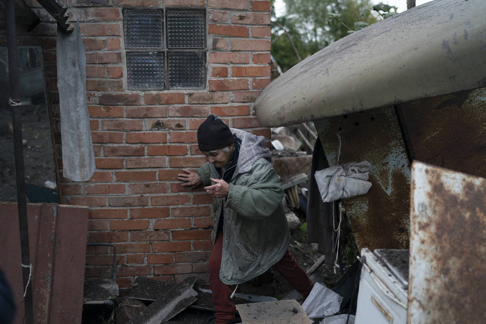 Valentina Bondarenko walks over debris outside her house that was heavily damaged after a Russian attack in Sloviansk