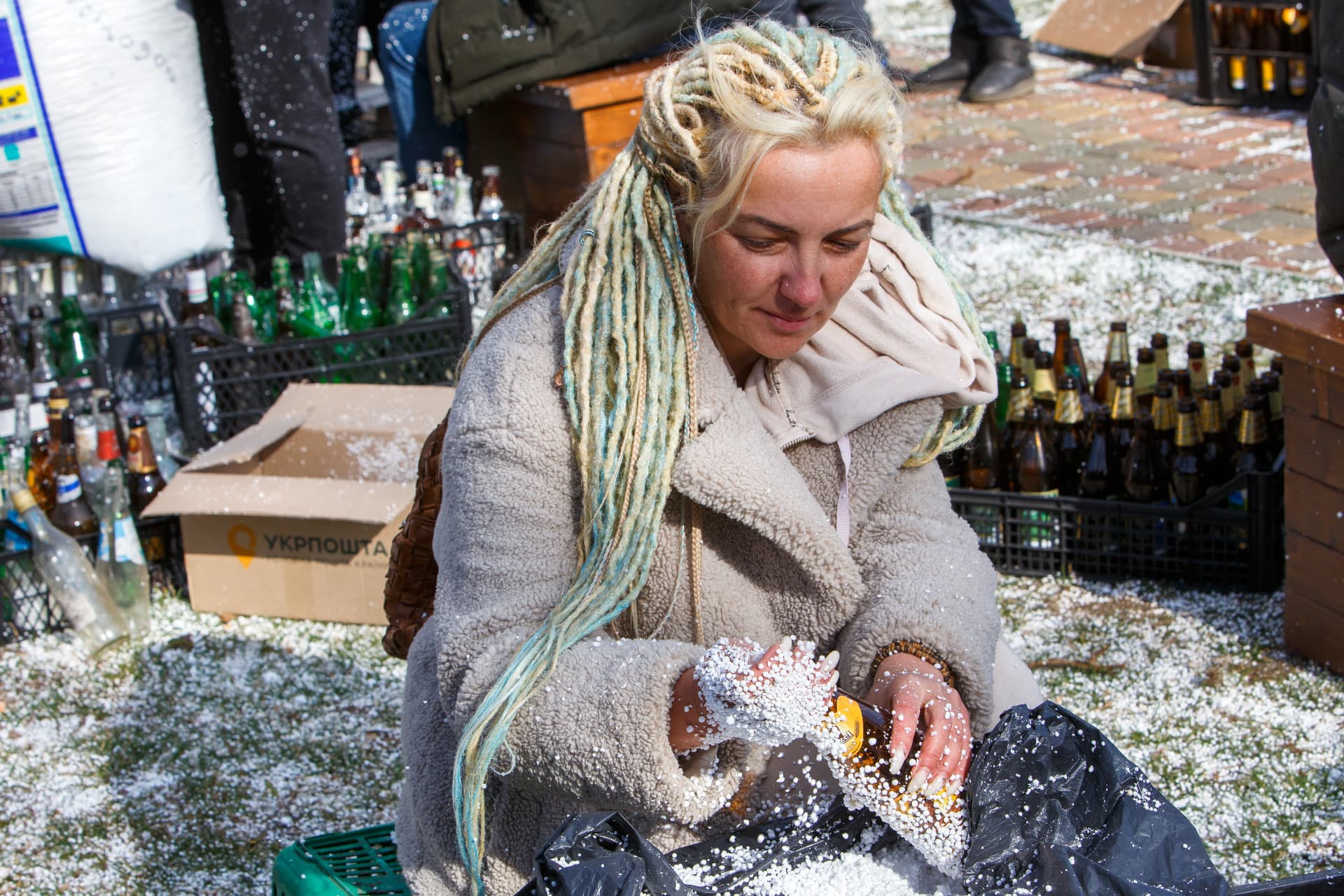 A woman adds foam plastic during an effort of making Molotov cocktails