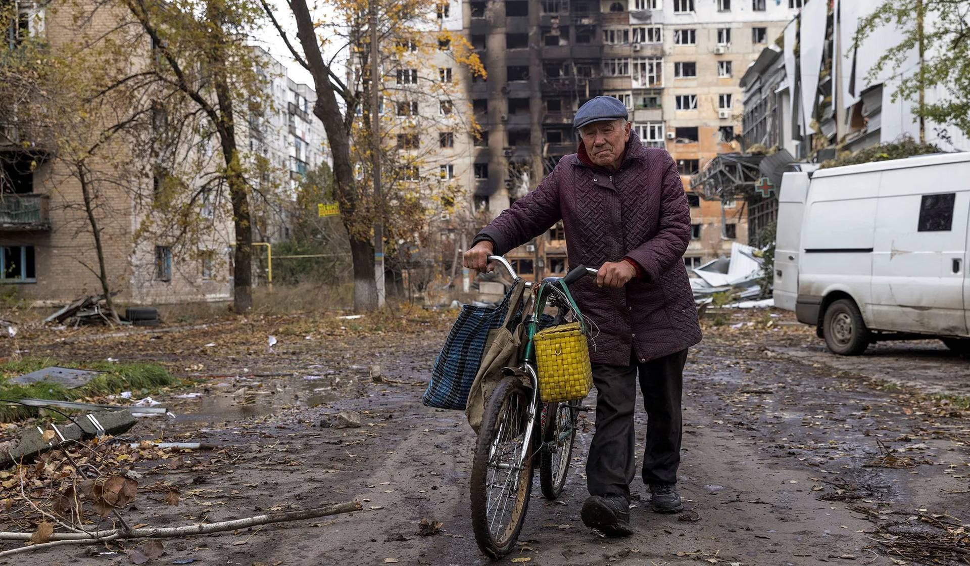 A local resident walks in front of damaged residential buildings in Avdiivka