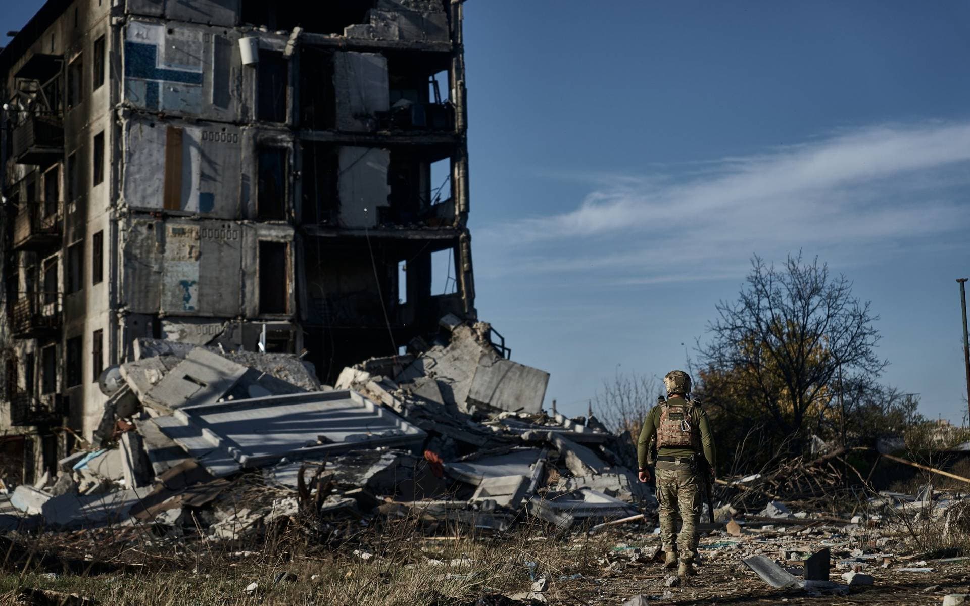 A Ukrainain soldier walks through the rubble of a destroyed building in the front line city of Avdiivka