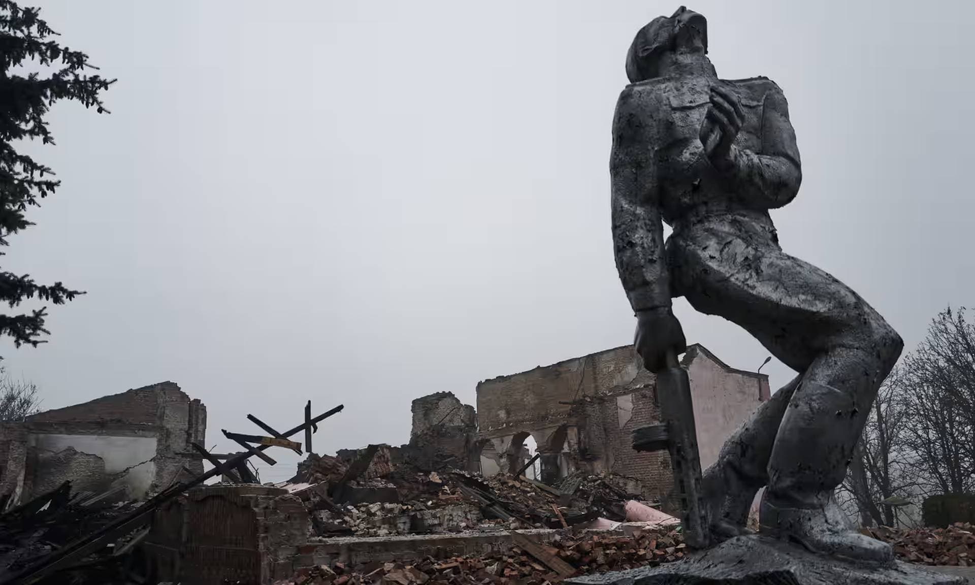 A statue of a Soviet soldier against the background of a house of culture destroyed by rocket fire in Avdiivka