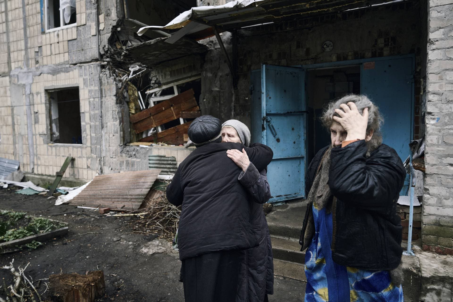 Local residents say goodbye to their neighbor as she leaves her home in war-hit Avdiivka