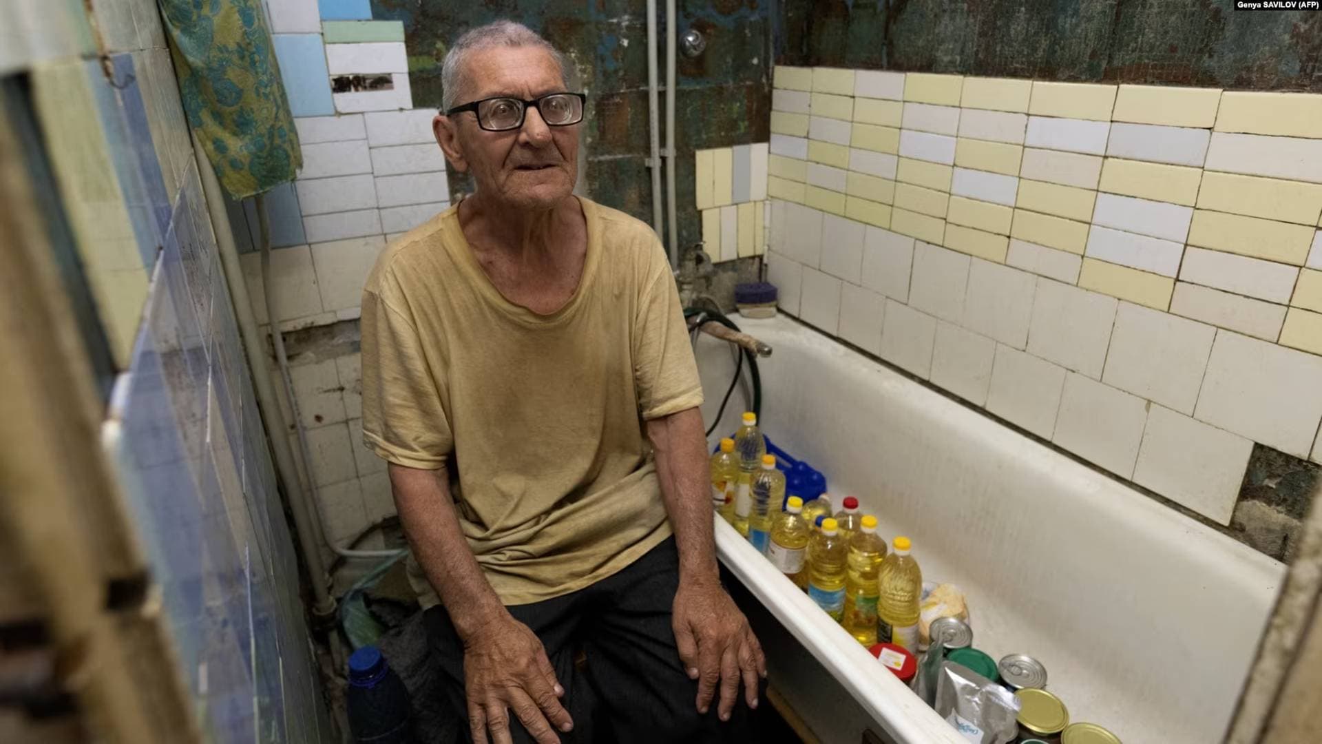 Viktor Grozdov sits in the bathroom of his damaged home in the eastern Ukrainian town of Avdiyivka