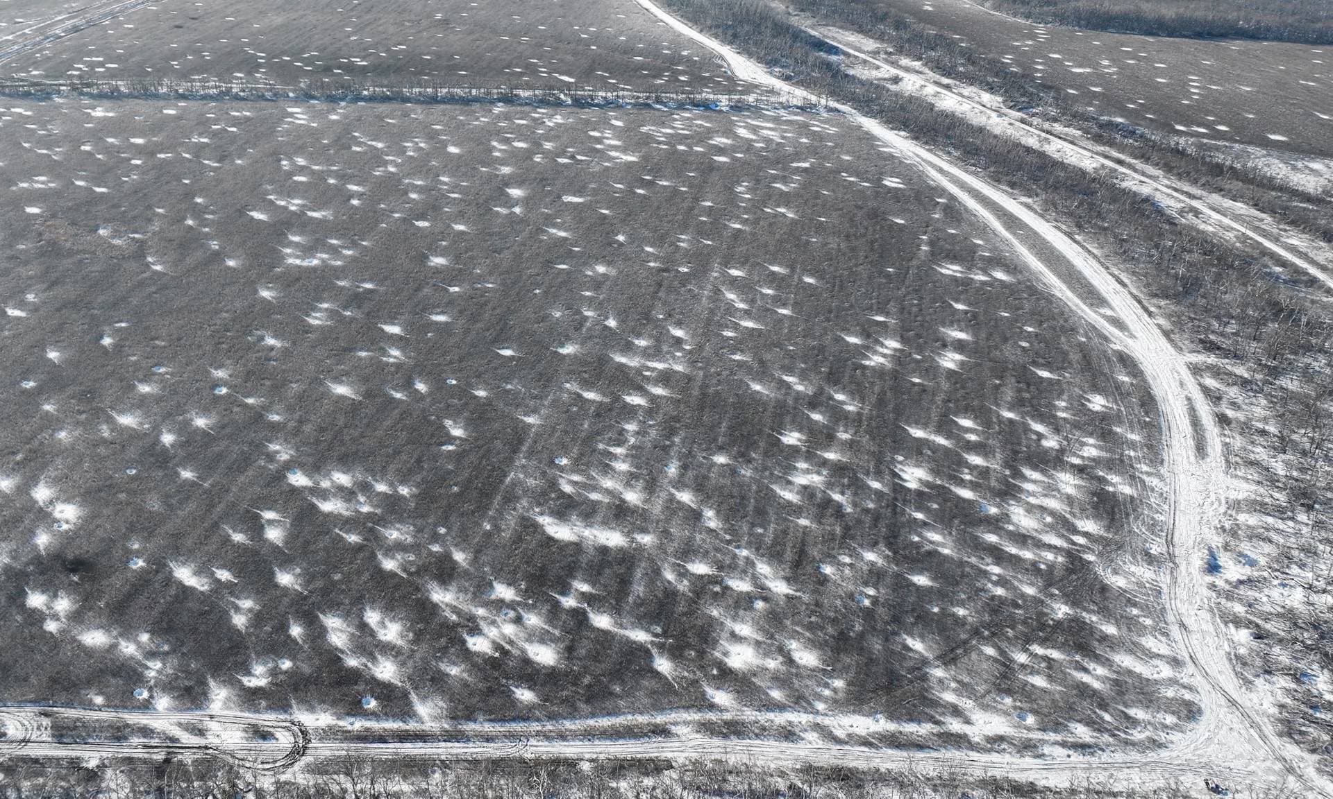 Snow-filled artillery shell craters on the frontline near Bakhmut