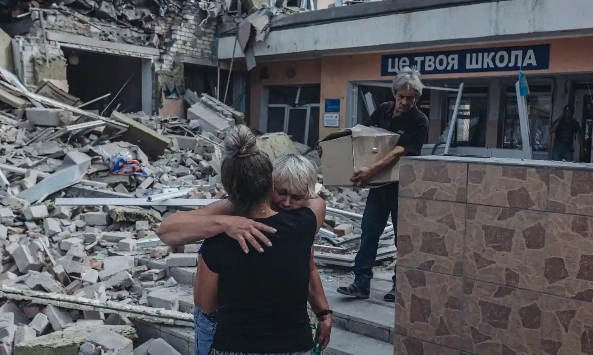 Two teachers hug when they see their school shelled by the Russian army in Bakhmut