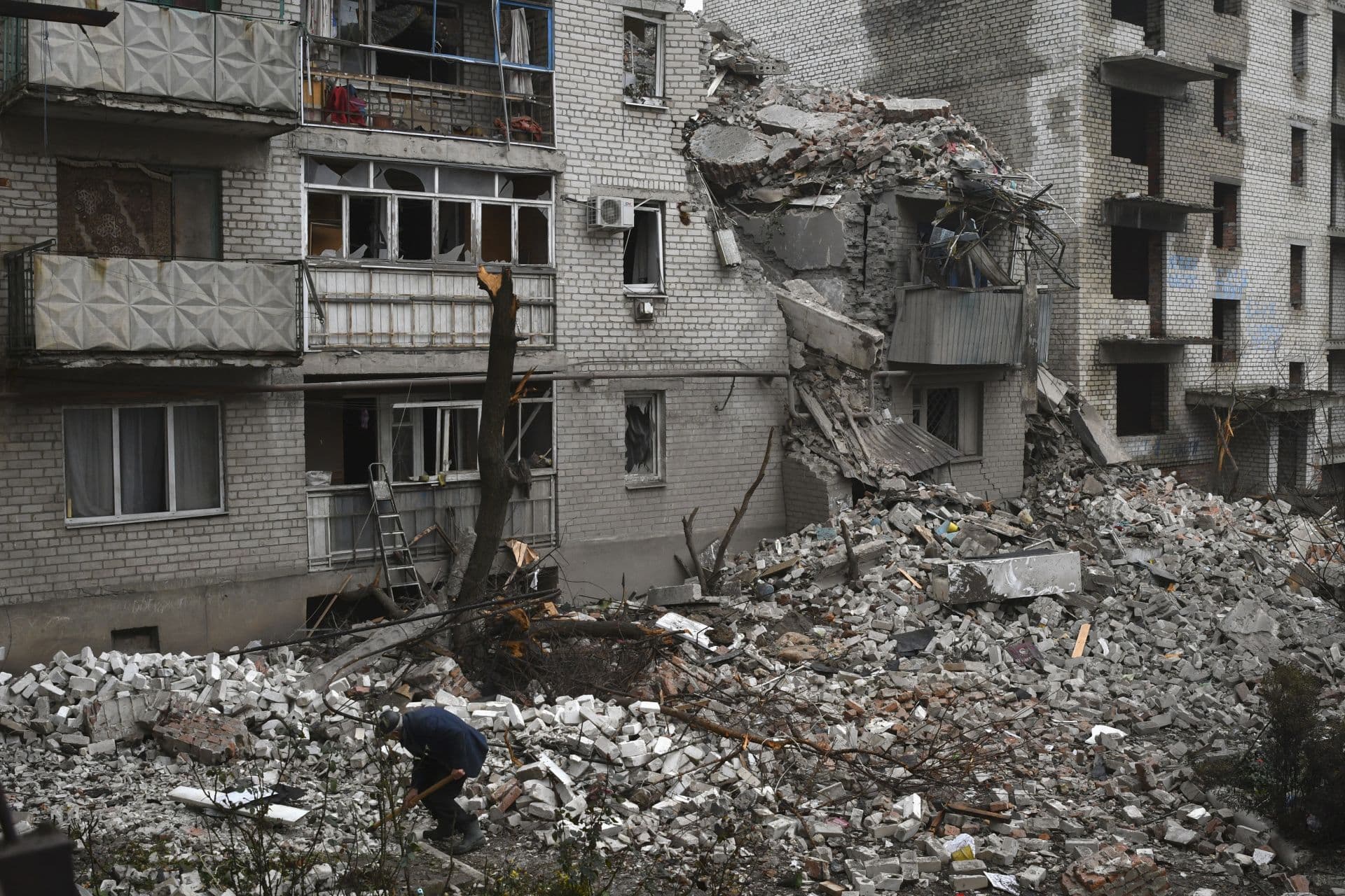 A man cleans debris of the destroyed house after recent Russian air strike in Chasiv Yar