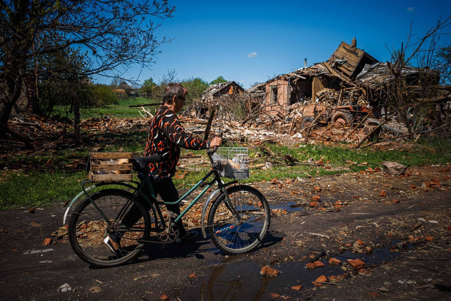 Valentyna Zaruba  carries bread on a bike to distribute it to her neighbours in Siversk