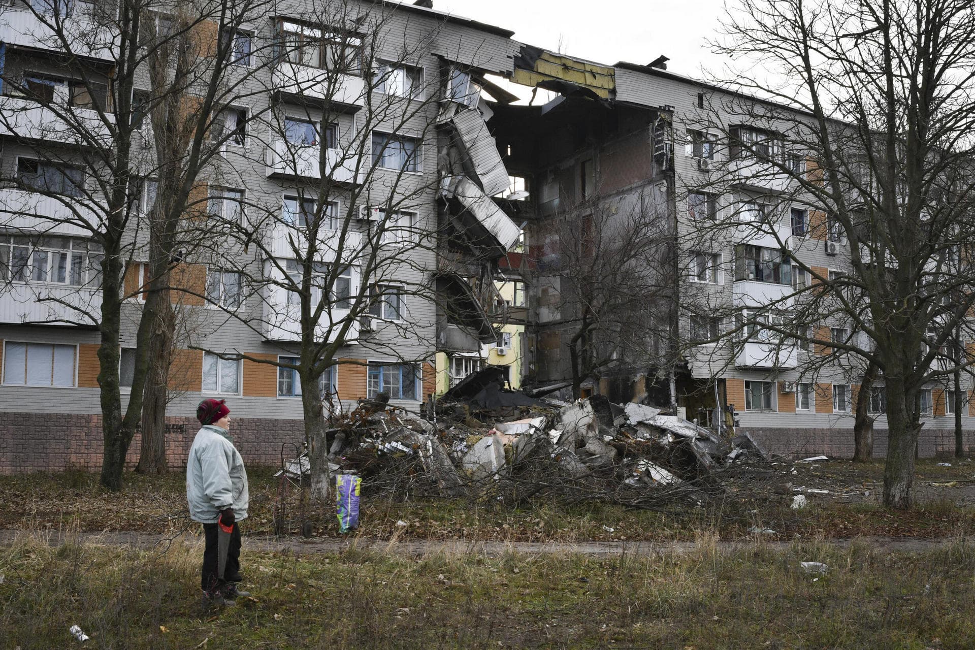 A woman passes by an apartment building damaged following by Russian shelling in Bakhmut