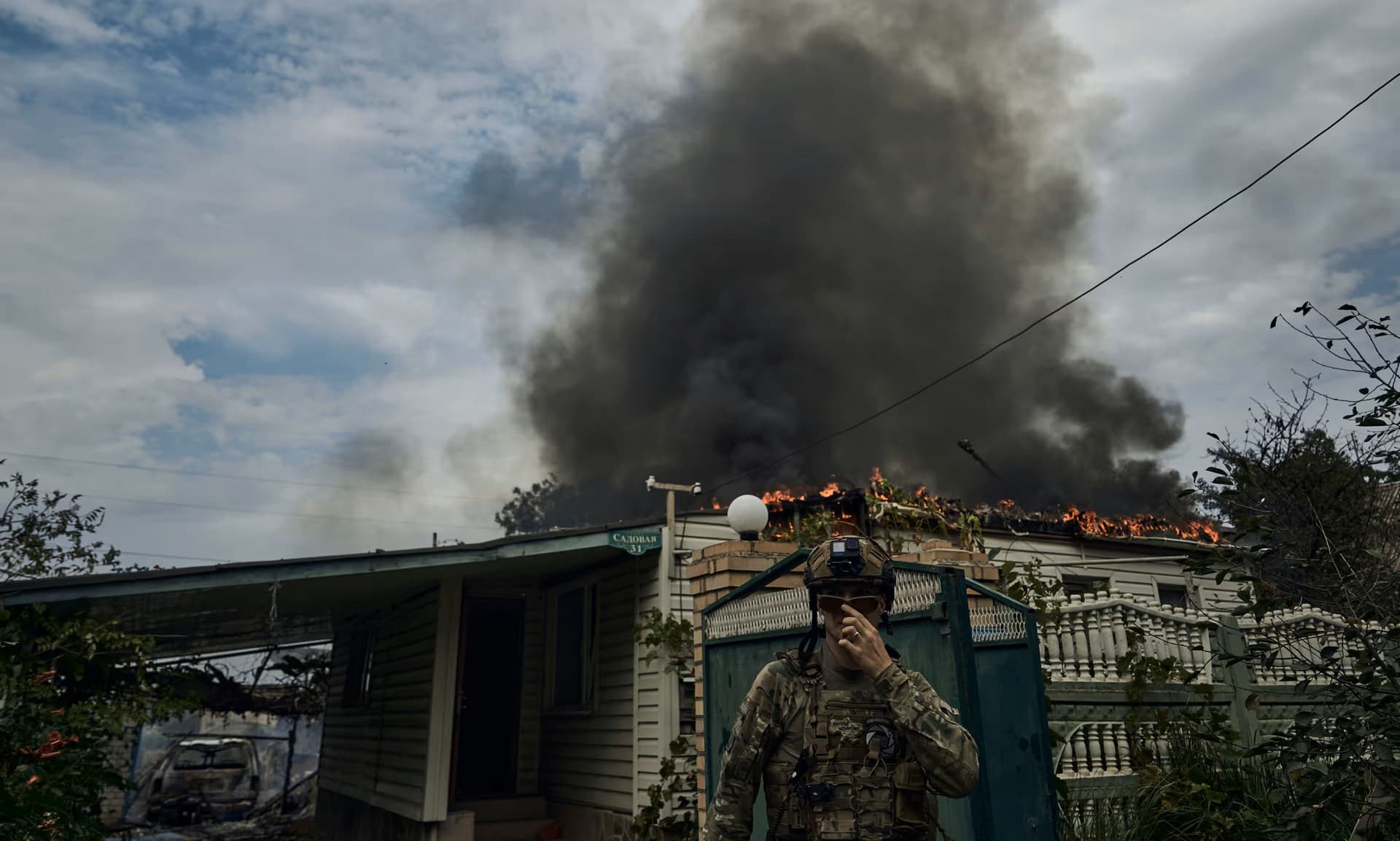 A Ukrainian soldier passes a burning house after Russian shelling near the frontline in Siversk