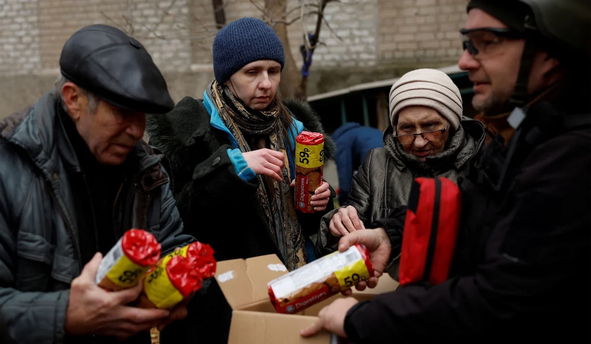 People come out of their underground shelters to receive aid from UA Future in Bakhmut