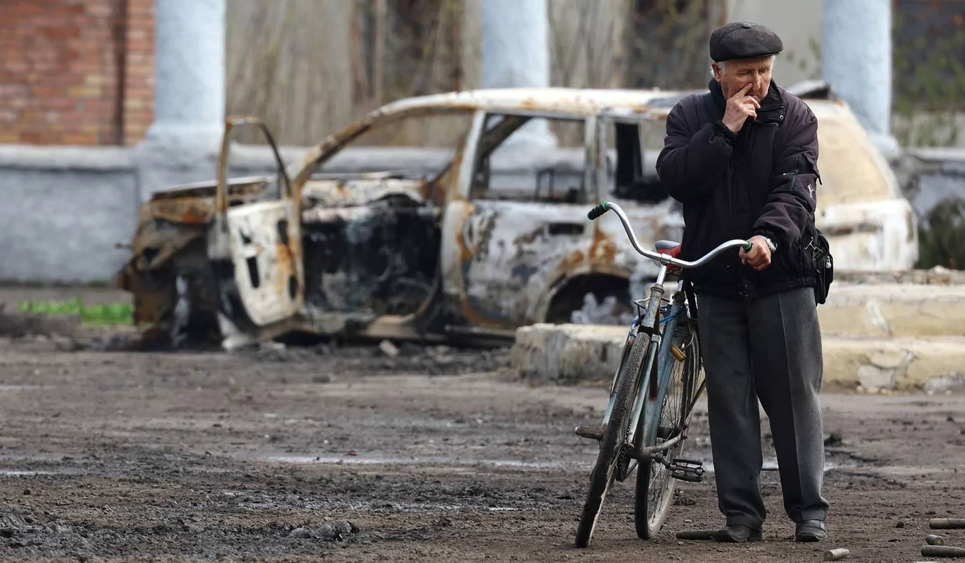 A villager near a wracked car during heavy fighting at the front line in Chasiv Yar