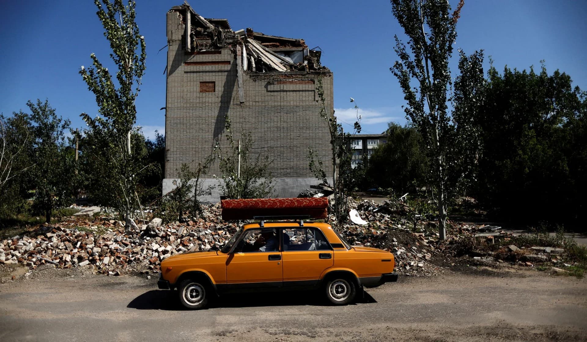 Ukrainian Arkadii, 62, drives a car after leaving his destroyed house in Toretsk