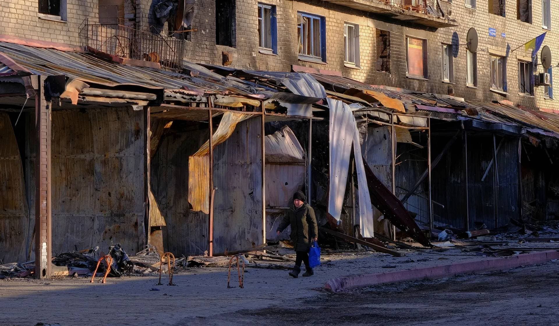 A local walks walks next to a damaged building in Siversk