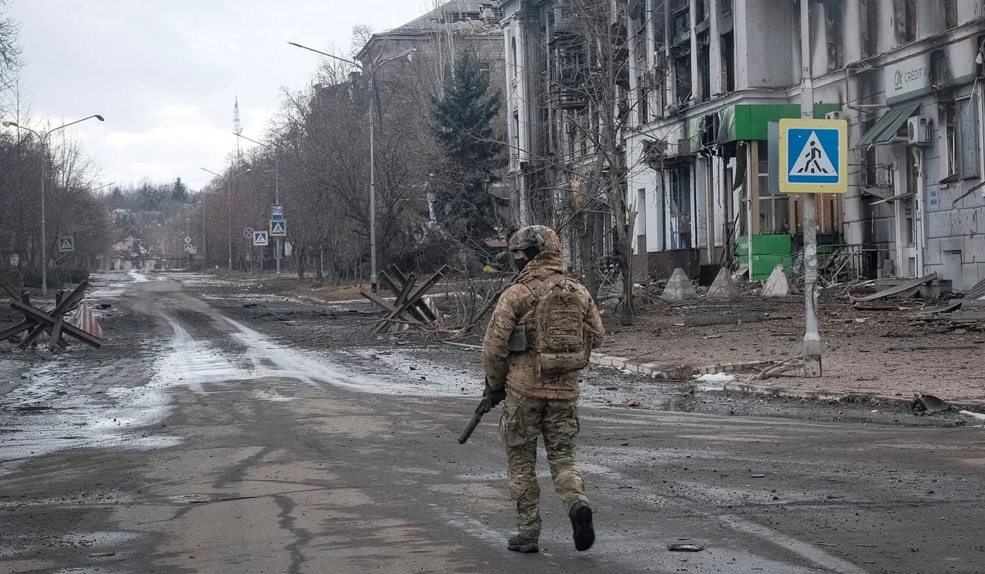 A Ukrainian serviceman walks an empty street as he patrols in the front line city of Bakhmut